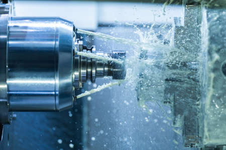 Vertical photo of industrial wet milling process with coolant flow under pressure and freezed...