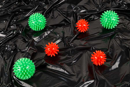 full frame abstract background of covid-19 virus models on crumpled black plastic body bagの写真素材