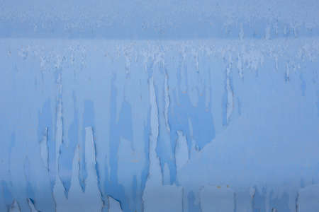peeling off old blue paint on vehicle - close-up with selective focusの写真素材