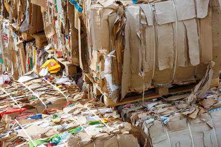 Tula, Russia - August 3, 2021: Crushed and compressed used cardboard packing poxes and paper stacked.のeditorial素材