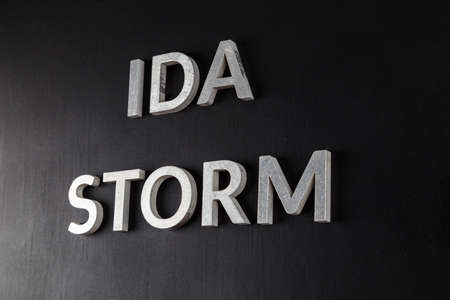 words ida storm laid with silver metal letters over dry black matte surface