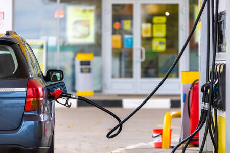 blue car refueling at gas station at summer dayの写真素材