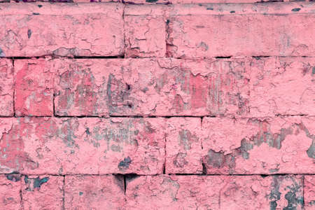 peeled off old pink paint on flat rough brick wall surface - full frame background and textureの写真素材