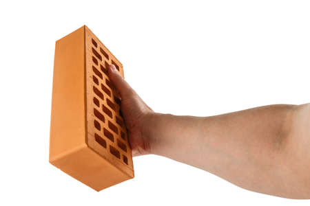 bare caucasian hand holding orange perforated clay brick - isolated