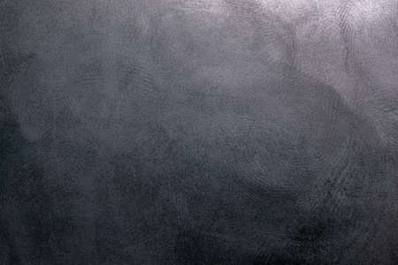 black plastic surface with multiple fingerprints, macro photo