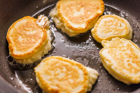 pancakes frying on skillet with vegetable oilの写真素材