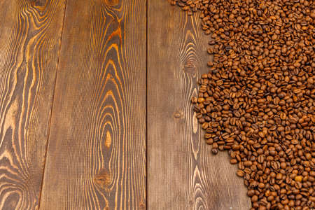 roasted coffee beans laid on brown wooden table surface