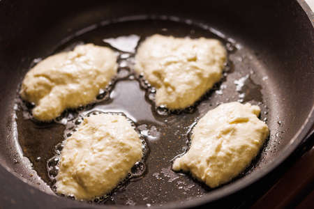 process of roasting traditional pancakes on skillet with sunflower seed oilの写真素材