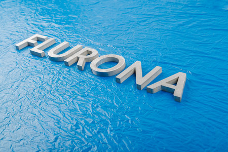 the word flurona laid with silver metal letters on crumpled blue plastic film background, diagonal perspective close-upの写真素材