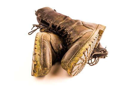 pair of dirty military style light ankle boots isolated on white backgroundの写真素材