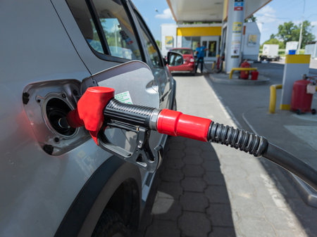 Silver car refuelling at the gas station, the concept of fuel energy