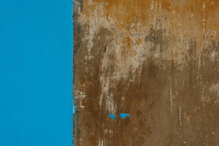 Old concrete with brown plaster wall partially painted in blue, texture and background.の写真素材