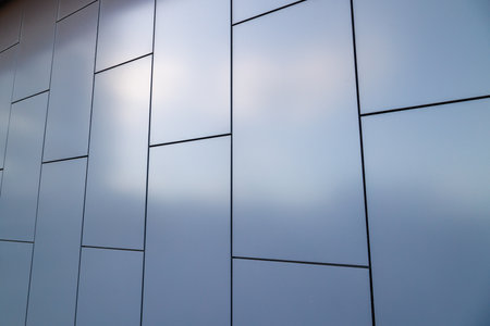 Outside wall of building covered with grayish blue painted metal rectangular panels - full-frame...
