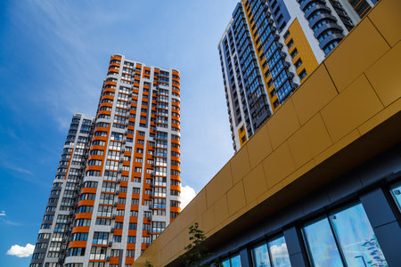 freshly built high rise apartment buildings on blue sky background with white cloudsの写真素材