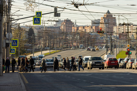 pedestrians crossing road in front of cityscape at sunny morning in Tula, Russiaのeditorial素材