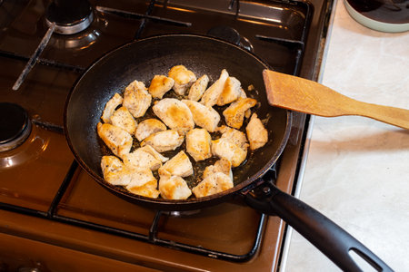 chicken breasts meat only on frying pan and wooden spatula, domestic healthy cuisine, real life situation.の写真素材