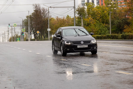 black 2014 Volkswagen Jetta 1.4 driving along the road at rainy day in Tula, Russiaのeditorial素材