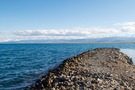 breakwater cape on Issyk-Kul lake at sunny autumn dayの写真素材