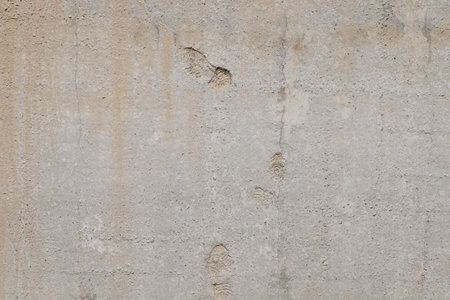 flat gray solid concrete wall with shoe soles imprints, full frame background and textureの写真素材