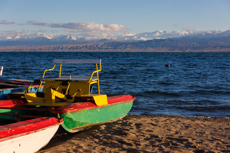 old pedal catamarans on beach of mountain lake at sunny autumnal afternoonの写真素材