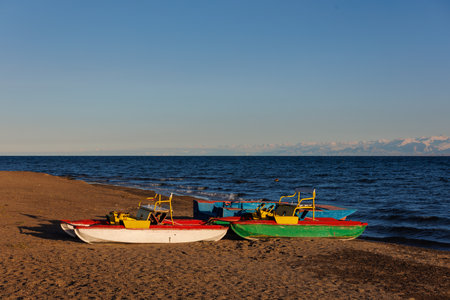 old pedal catamarans on beach of mountain lake at sunny autumnal afternoonの写真素材