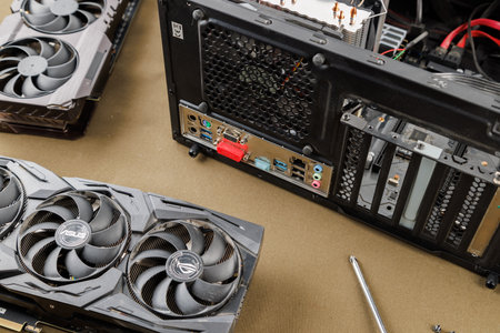 graphics card upgrading concept, two gaming graphics cards near desktop miditower ATX pc case on tan fabric backgroundのeditorial素材