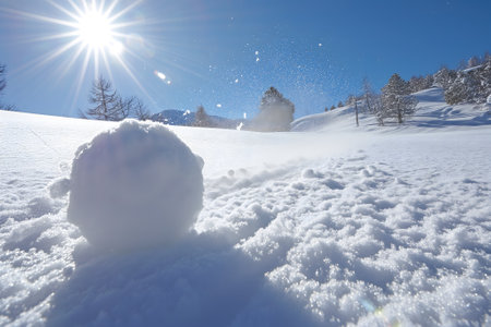 Snowball on snow covered ground at sunny winter day for snow ball effect conceptの素材
