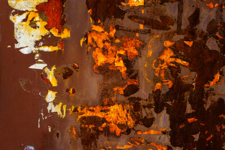 Close up of a brown rusted sheet metal surface with leftovers of peeled off paper advertisementsの写真素材