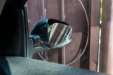 broken side window of black car in rusted gate background, view from insideの写真素材