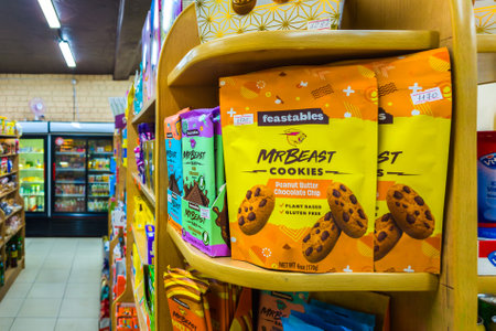 Chocolate bars and cookies by Mr Beast on small store shelf, his company called Feastables that makes these and other treats.のeditorial素材
