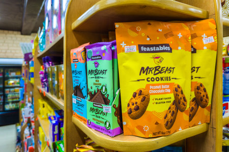 Chocolate bars and cookies by Mr Beast on small store shelf, his company called Feastables that makes these and other treats.のeditorial素材