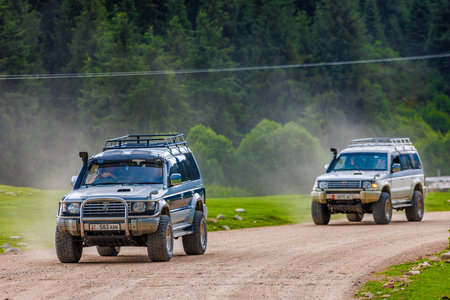 Embark on an OffRoad Adventure in the Forest SUVs Driving on a Dusty Dirt Roadのeditorial素材