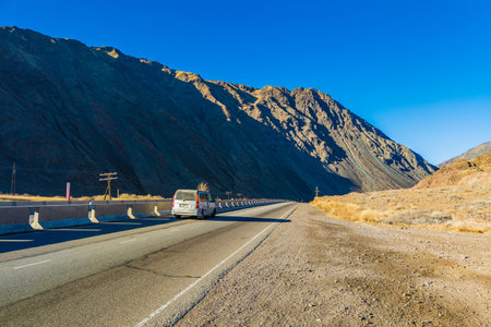 Car is driving along the road through natural Kyrgyzstan mountain landscape with concrete barrier in Boom Gorge.のeditorial素材