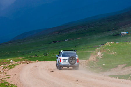 an adventurous offroad journey through remote countryside in mountain ravine with dramatic pre-storm cloudy skiesのeditorial素材