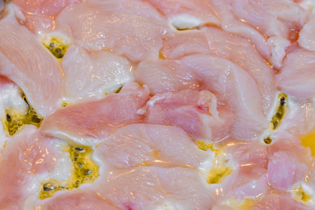 closeup full-frame background of raw chicken breast meat just starting to roastの写真素材