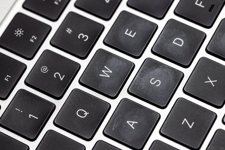 keyboard of silver colored laptop with fingerprintsの写真素材