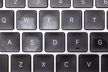 keyboard of silver colored laptop with fingerprints
