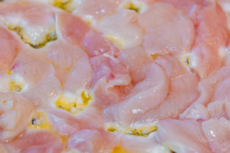 closeup full-frame background of raw chicken breast meat just starting to roastの写真素材