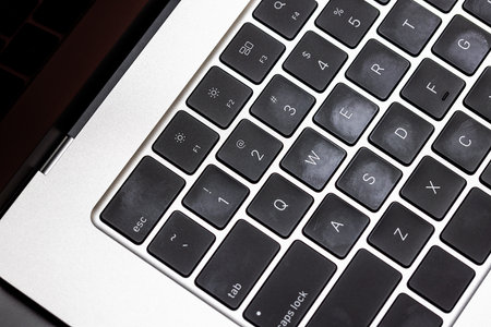 keyboard of famous silver colored laptop with fingerprints