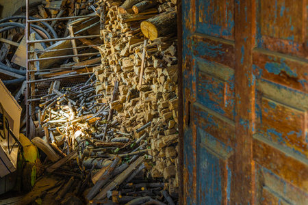 barn with chunks of firewood behind old doorの写真素材