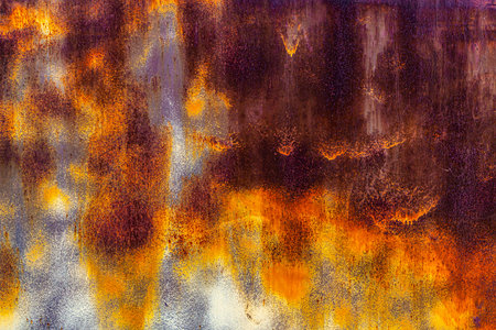 Brown sheet metal surface showing significant rust spots emerging from underneath a thin, uneven...