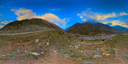 Equirectangular panorama of dramatic mountain range towers over a peaceful valley, with river...