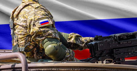 Russia national tricolor flag with soldier at machine gun turret in front of it. Closeup side view.の写真素材