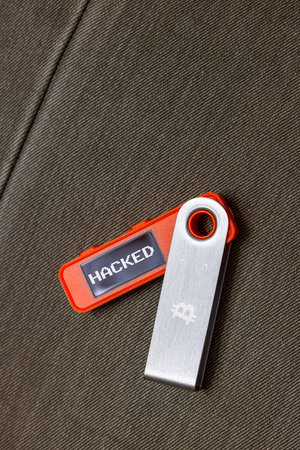 orange hardware Bitcoin cold wallet with stolen message on screenの写真素材