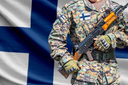 Finland flag with soldier in military uniform holding assault rifle in front of it