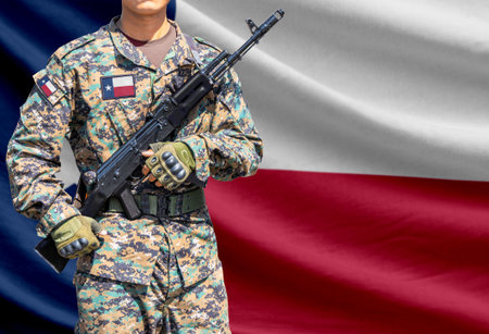 Texas US state flag with soldier in military uniform holding assault rifle in front of it