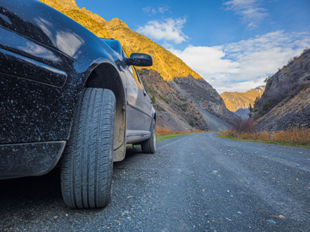 Car parked on dirt road in mountainous region during daytimeの写真素材