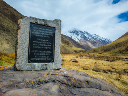 Stone monument Ak-Suu mineral water source at spring day.