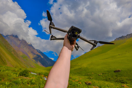 Male adult preparing drone for flight in mountainous region