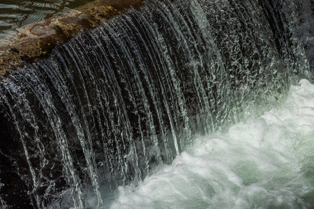 water flowing over concrete structure at sunny day